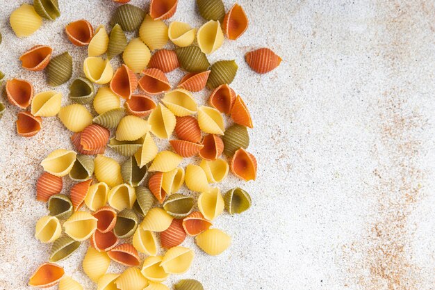 Pasta conchiglie rauwe gekleurde mix maaltijd eten snack op tafel kopieer ruimte voedsel achtergrond