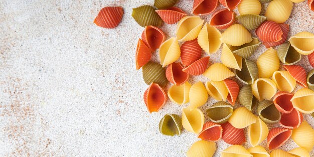 Pasta conchiglie rauwe gekleurde mix maaltijd eten snack op tafel kopieer ruimte voedsel achtergrond