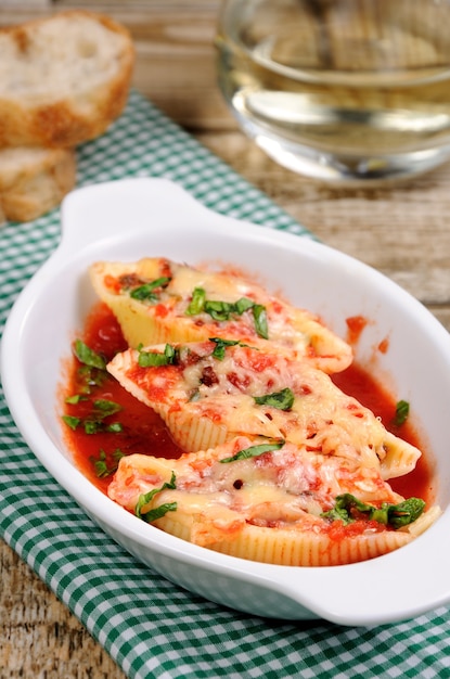 Pasta conchiglioni shells stuffed meat mince with spinach and tomato sauce  Parmesan cheese