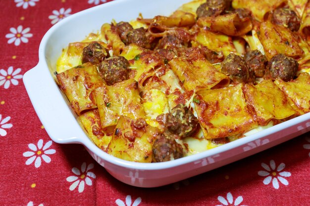 Pasta cooked in the oven with tomato sauce meatballs and eggs ready to eat baked pasta in a porcelain dish