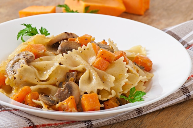 Pasta in cream sauce with slices of pumpkin and mushroom