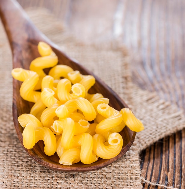 Photo pasta curls on a wooden spoon