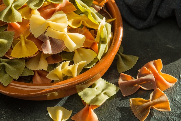 Pasta dish on clay bowl with wooden spoon