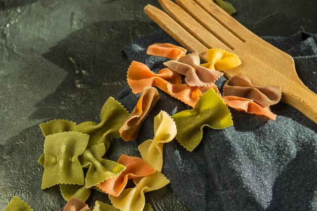 Foto piatto di pasta sulla ciotola di argilla con un cucchiaio di legno