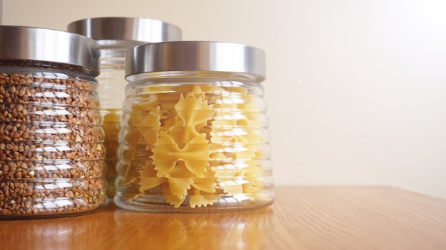 Pasta- en boekweitmaaltijden. Gezond koken in glazen pot containers op houten tafel. Evenwichtige dieetvoeding.