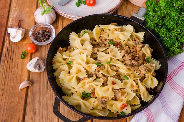 Pasta farfalle met gebakken vlees, champignons en groenten