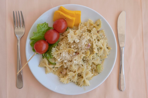 Pasta farfalle met kersentomaat en kaas in witte plaatclose-up