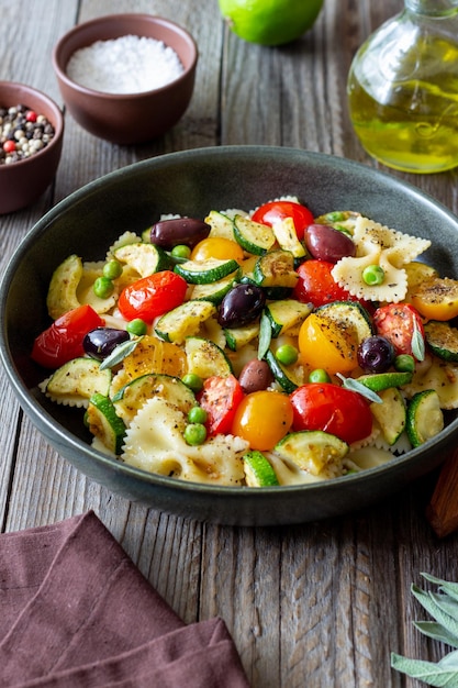 Pasta farfalle met tomaten courgette erwten kalamata olijven en salie gezond eten vegetarisch eten