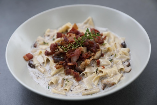 Pasta fettuccine alfredo witte saus met ham, spek en champignons