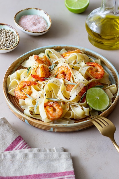 Pasta fettuccine in een romige saus met garnalen limoen en salie Italiaans eten