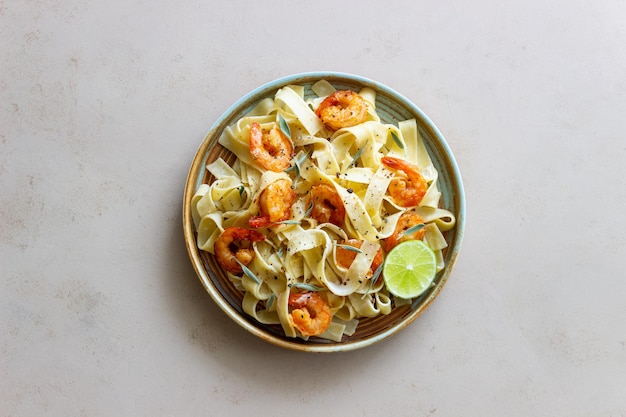 Pasta fettuccine in een romige saus met garnalen limoen en salie Italiaans eten