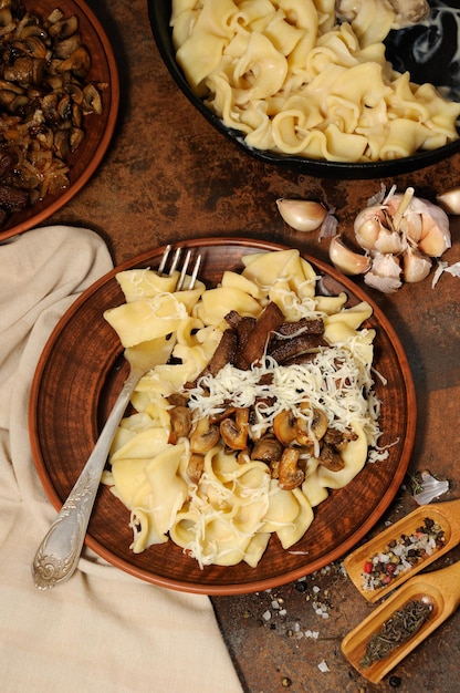 Foto pasta fettuccine met gebakken champignons, beef stroganoff, ui gekruid met kaas