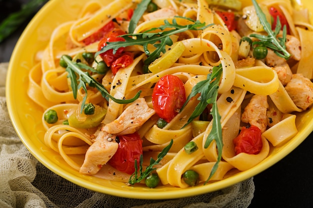 Pasta Fettuccine met tomaat, courgette en kipfilet in een kom