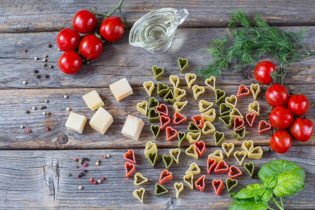 pasta in the form of hearts, tomatoes, basil, olive oil, dill, pepper, cheese