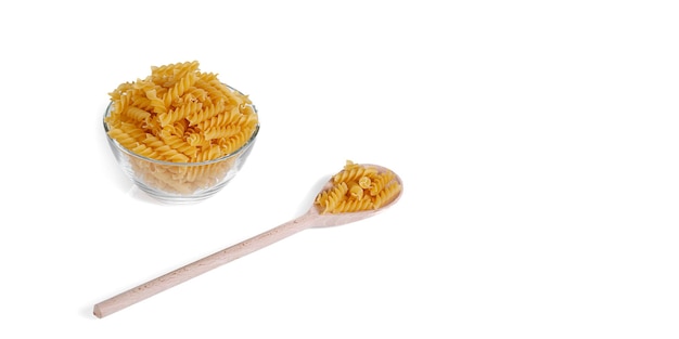 Pasta in the form of a spiral on a plate spoon texture on a white background