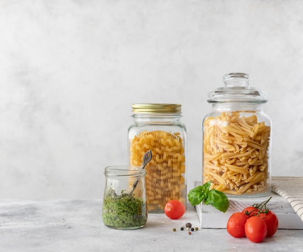 Pasta in un barattolo di vetro e olio d'oliva in una bottiglia