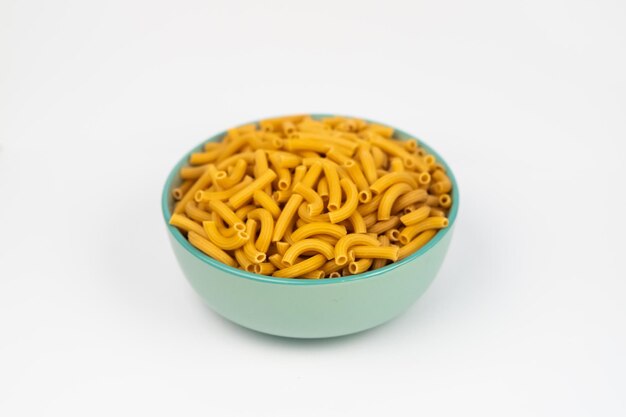 pasta horns in a green bowl on a white background