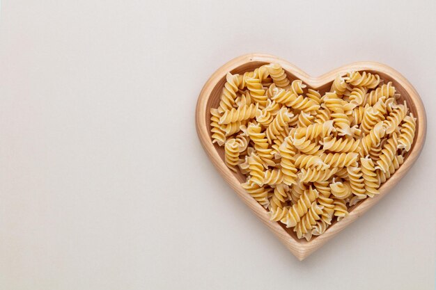 Pasta in een hartvormige houten kom