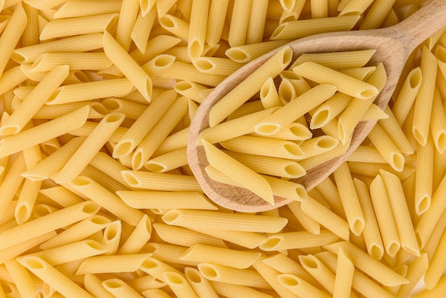 Pasta in houten lepel geïsoleerd op een witte achtergrond.