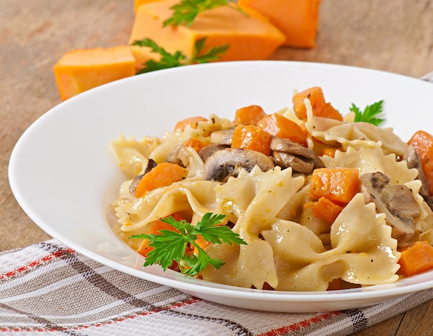 Pasta in roomsaus met plakjes pompoen en champignon