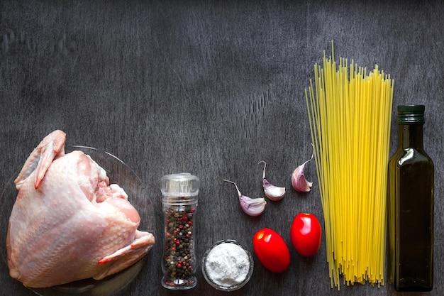 Pasta ingrediënten kipfilets cherrytomaatjes spaghetti pasta olie kruiden en knoflook op het hout