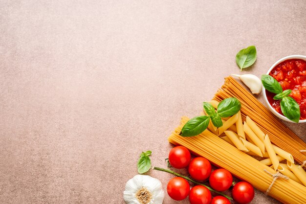 Pasta ingredients on light rustic background with copyspace