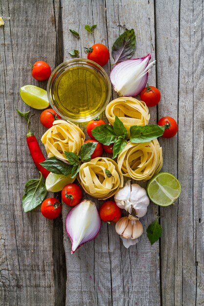 Pasta and ingredients on rustic background