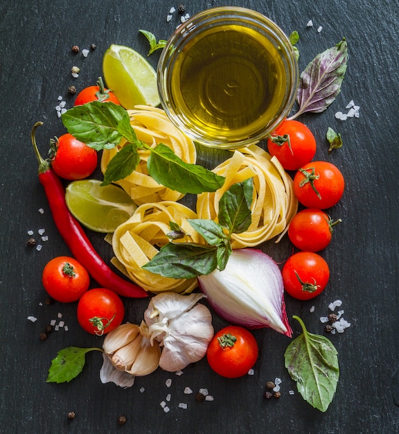 Pasta and ingredients on rustic background