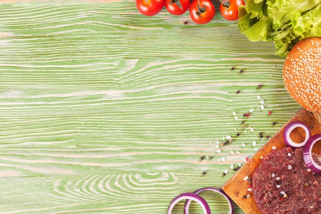 Foto ingredienti della pasta e spezie su una superficie di legno verde