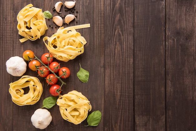 Pasta ingredients. tomato, garlic, pepper, and mushroom on wooden background