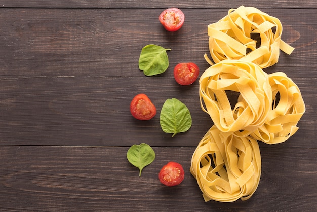 Pasta ingredients. tomato on the wooden background