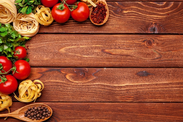 Pasta and ingredients on wooden background. Copyspace