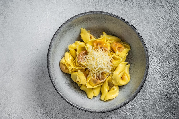 Pasta Italiana ravioli with Mozzarella cheese and Tomato in plate. White background. Top view.