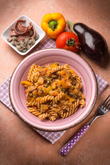 Foto pasta met aubergine kappertjes ansjovis en paprika