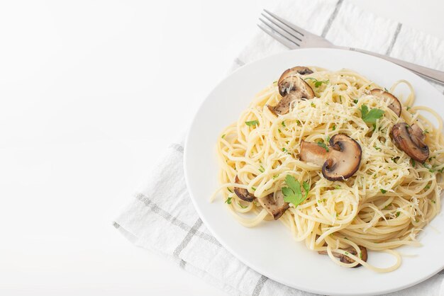 pasta met champignons en kaas op een wit bord