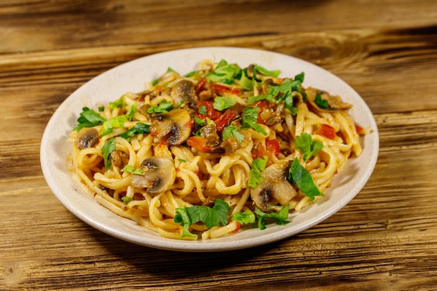 Pasta met champignons en tomatensaus op houten tafel