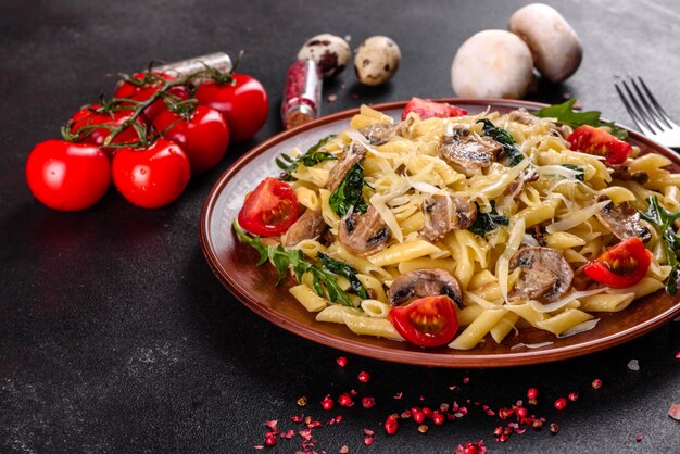 Pasta met champignons, kaas, spinazie, rukkola en kerstomaatjes. Italiaans gerecht, mediterrane cultuur