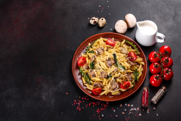 Pasta met champignons, kaas, spinazie, rukkola en kerstomaatjes. italiaans gerecht, mediterrane cultuur