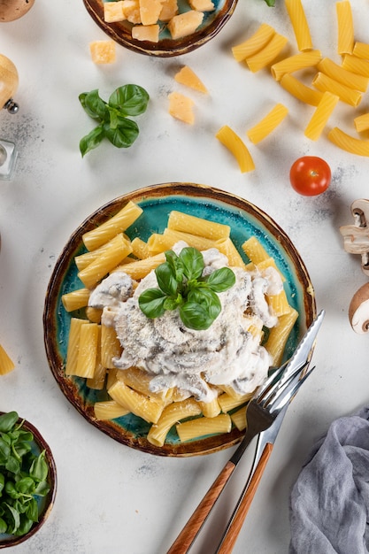 Pasta met champignonsaus en basilicum en harde kaas