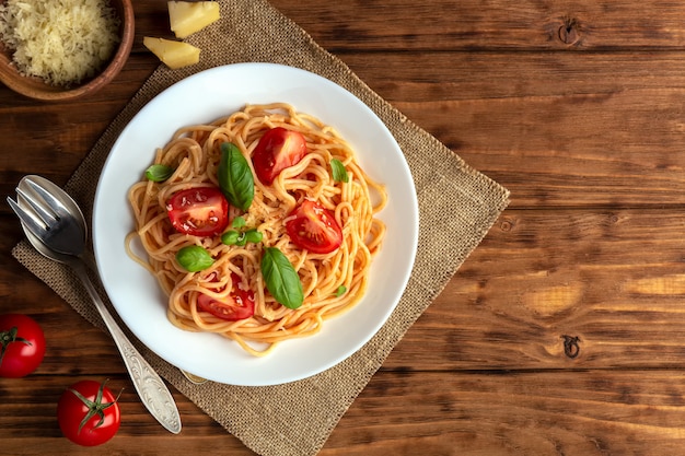 Pasta met cherrytomaatjes en kaas op een bruin houten ruimte