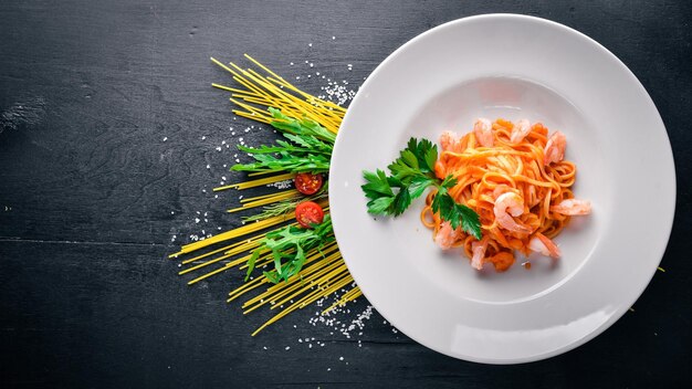 Pasta met garnalen en tomatensaus Italiaans traditioneel eten Op een houten ondergrond Bovenaanzicht Vrije ruimte voor uw tekst