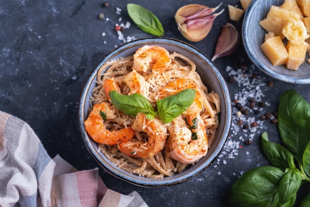 Pasta met garnalen in een plaat, close-up, bovenaanzicht. Pasta koken concept, ingrediënten en kruiden op een tafel met een schotel.