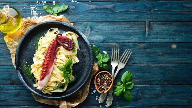 Pasta met octopus op een stenen bord Bovenaanzicht Gratis kopieerruimte