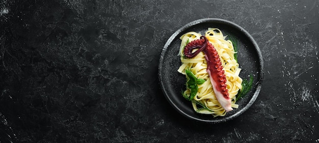 Pasta met octopus op een stenen bord Bovenaanzicht Gratis kopieerruimte