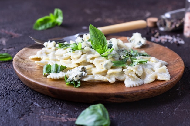 Pasta met romige saus met basilicum en gorgonzola-kaas.