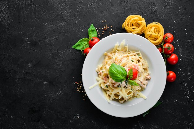 Pasta met spek en cherrytomaatjes. Italiaans gerecht. Vrije ruimte voor uw tekst. Bovenaanzicht.