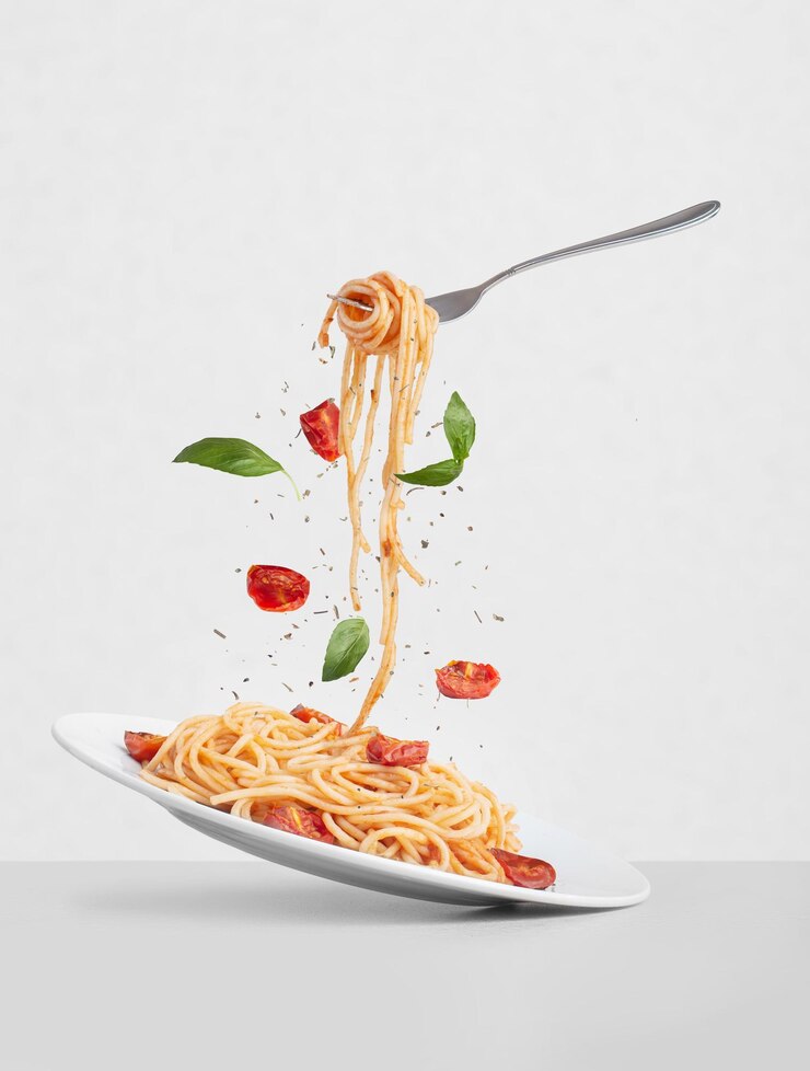 Foto pasta met tomaten en basilicum op een grijze achtergrond