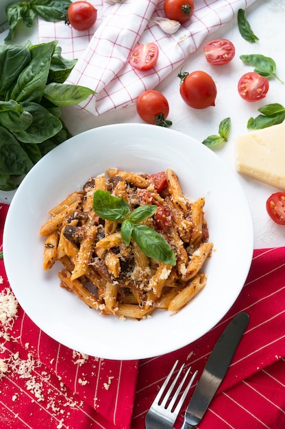 Foto pasta met tomaten, parmezaanse kaas en basilicum. in een witte plaat