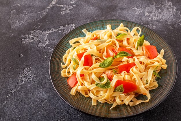 Pasta met tomatensaus geserveerd met basilicum