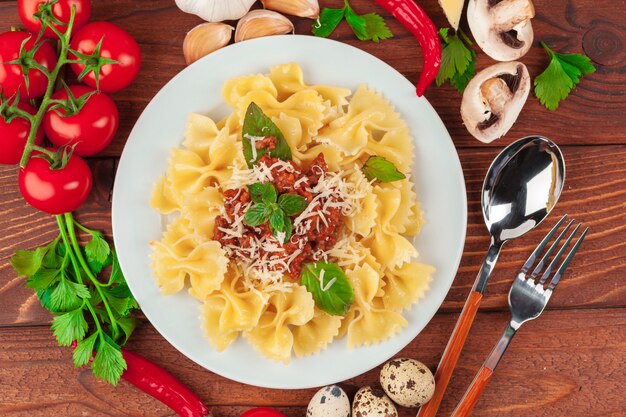 Pasta met vlees, tomatensaus en groenten op tafel